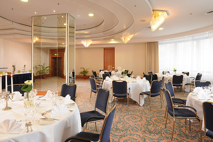 Salon Dresden au Maritim Hotel Magdeburg avec tables élégamment dressées, chandeliers et éclairage raffiné pour événements festifs.
