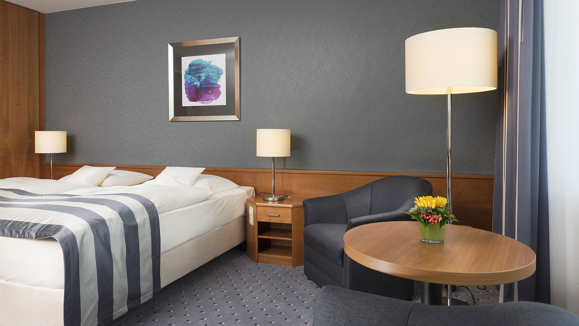Chambre confortable au Maritim Hotel Ulm avec lit double, coin salon et déco élégante