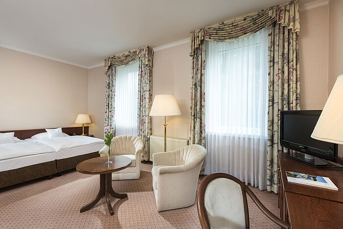 Spacious double room with two windows and seating area at Maritim Hotel Bad Wildungen