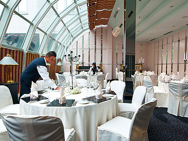Elegantly set room for banquets and celebrations with glass roof at Maritim Hotel Munich