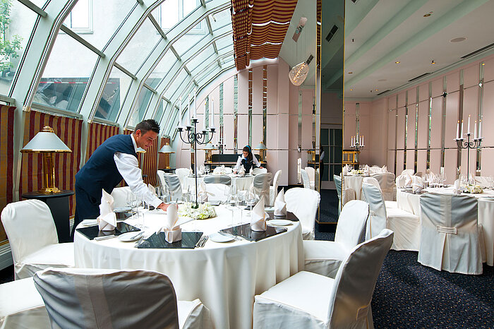 Sala elegantemente decorada para banquetes con techo de cristal en el Maritim Hotel Múnich