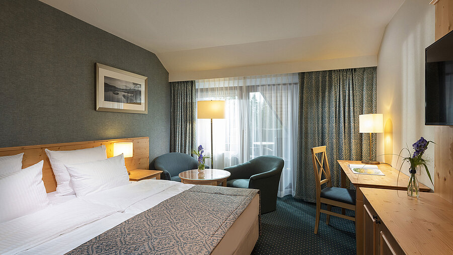 Habitación doble acogedora con escritorio y zona de estar en el Maritim Hotel Titisee