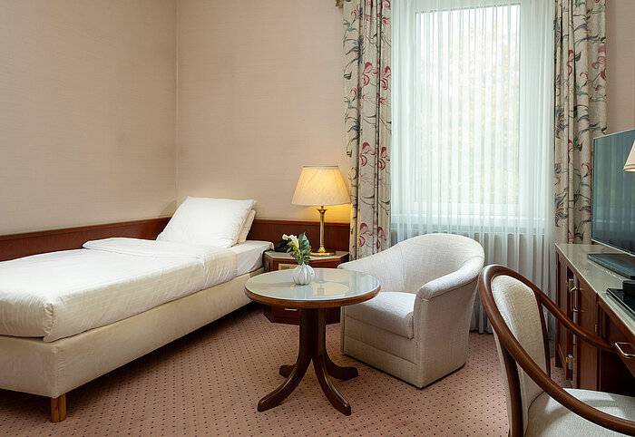 Camera Classic singola Camera Classic singola con letto, area salotto, scrivania e ampia finestra in stile luminoso al Maritim Hotel Bad Wildungen.