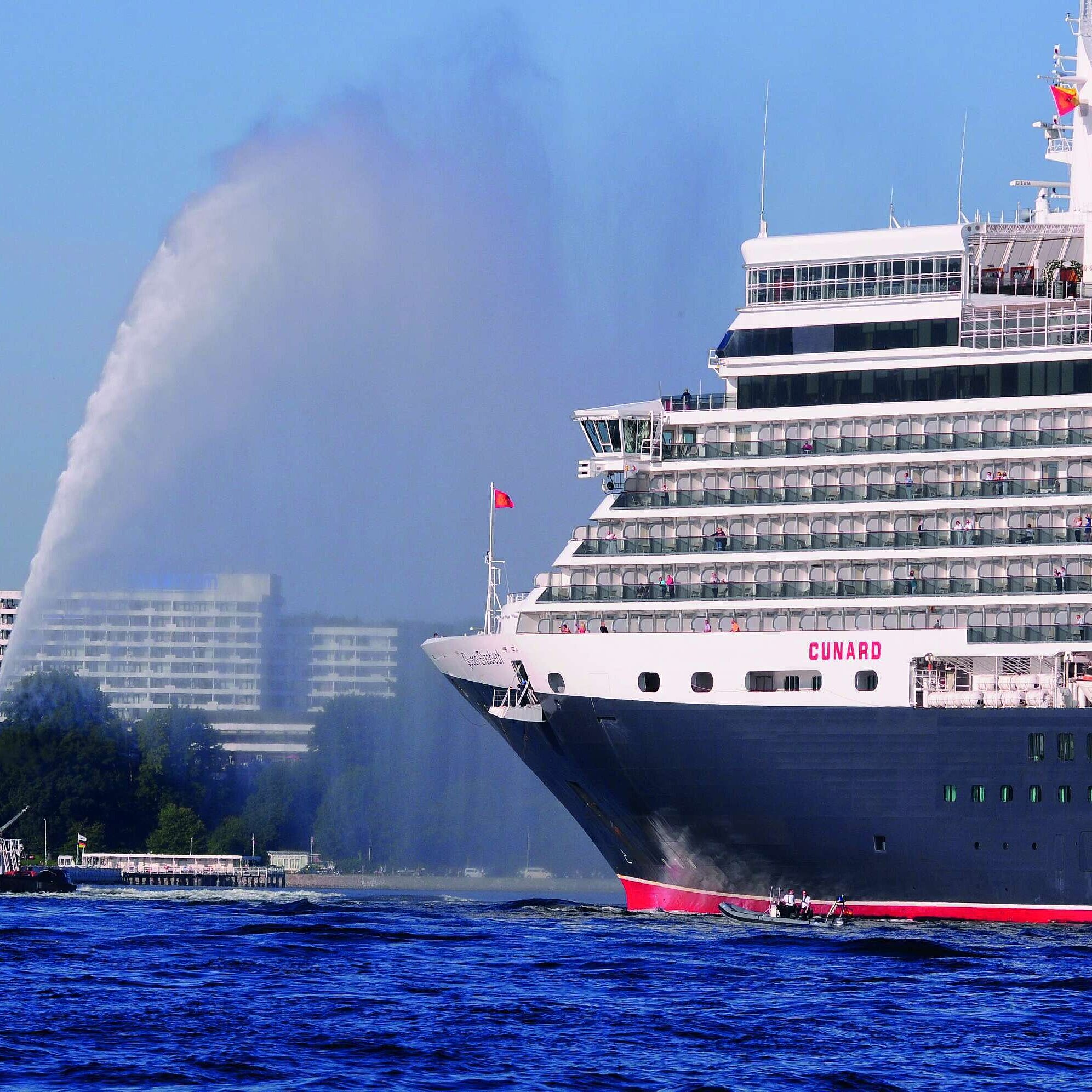 Vista exterior del Maritim Hotel Kiel, en primer plano el crucero Queen Elizabeth y un remolcador en el agua.