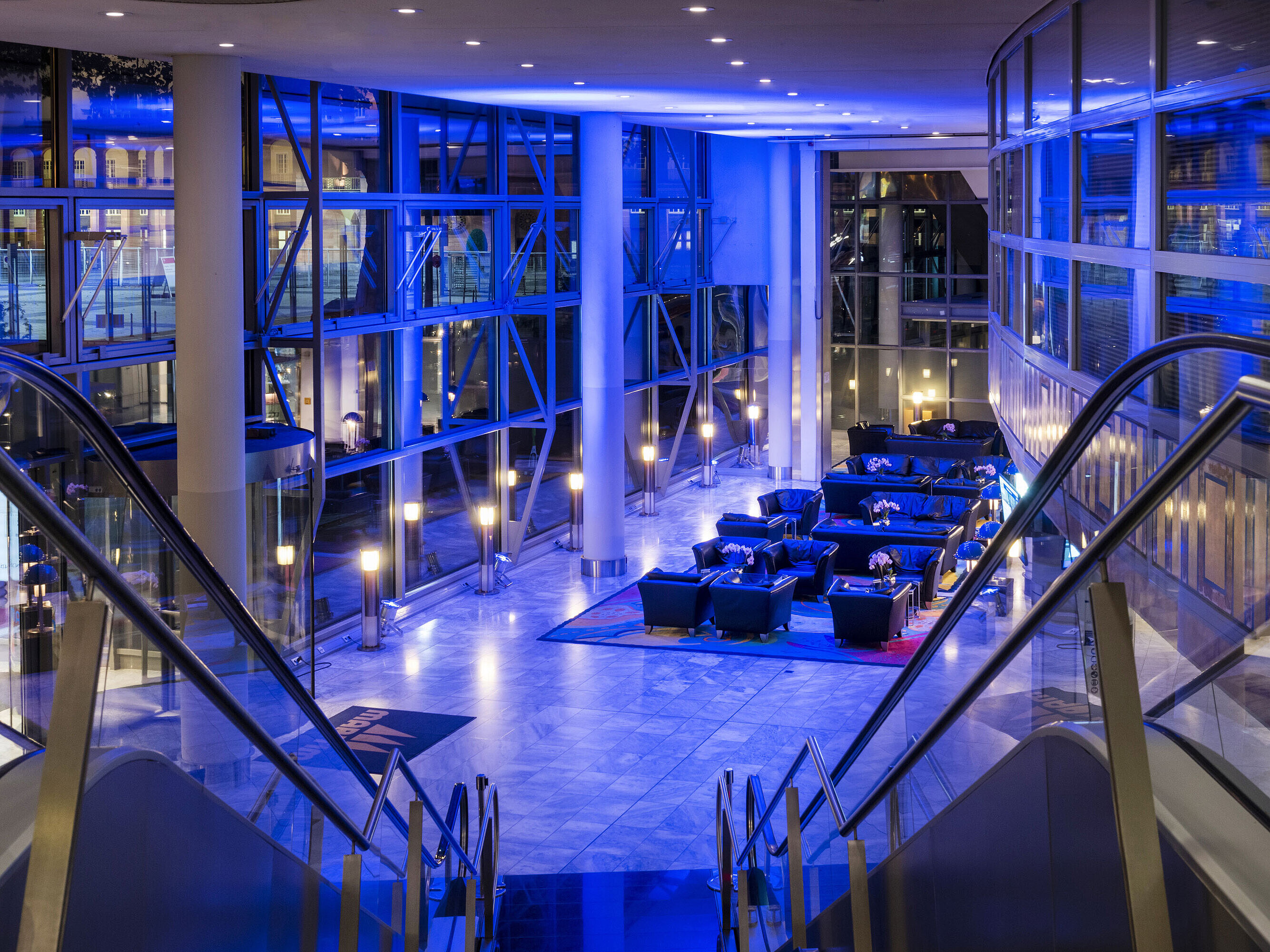 Lobby illuminata modernamente di notte con eleganti aree lounge al Maritim Hotel Frankfurt.