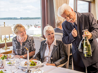 Waiter presents fine wines to guests in the restaurant of Maritim Hotel Travemünde.