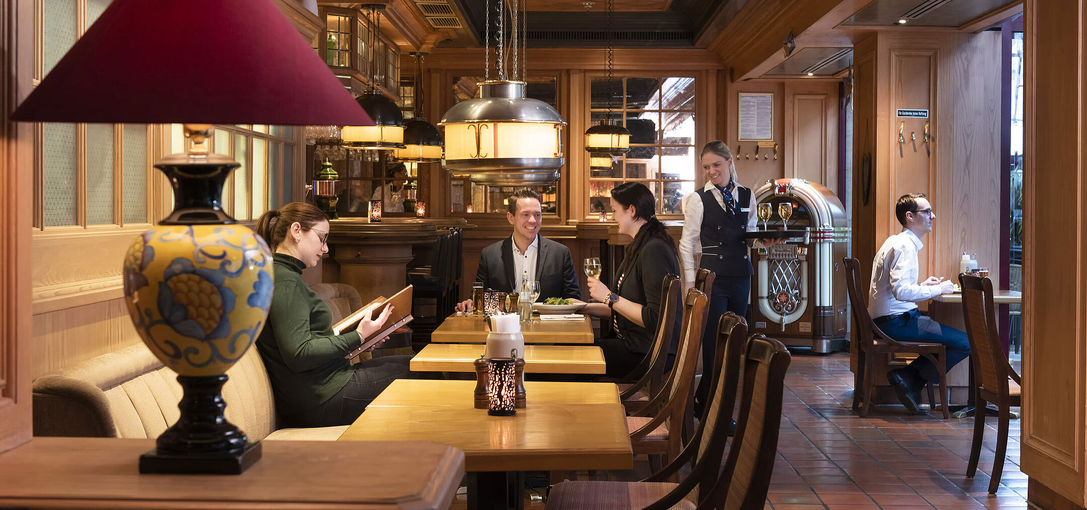 Clientes en la taberna "Kölsche Stuff" disfrutan de un ambiente acogedor y decoración rústica.