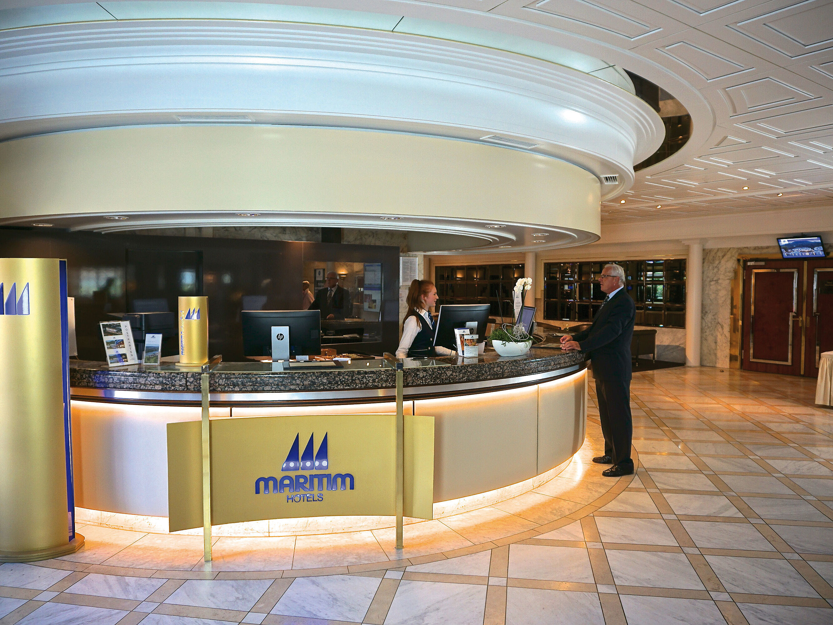 Bienvenida cálida en la recepción del Maritim Hotel Königswinter con un interior elegante.