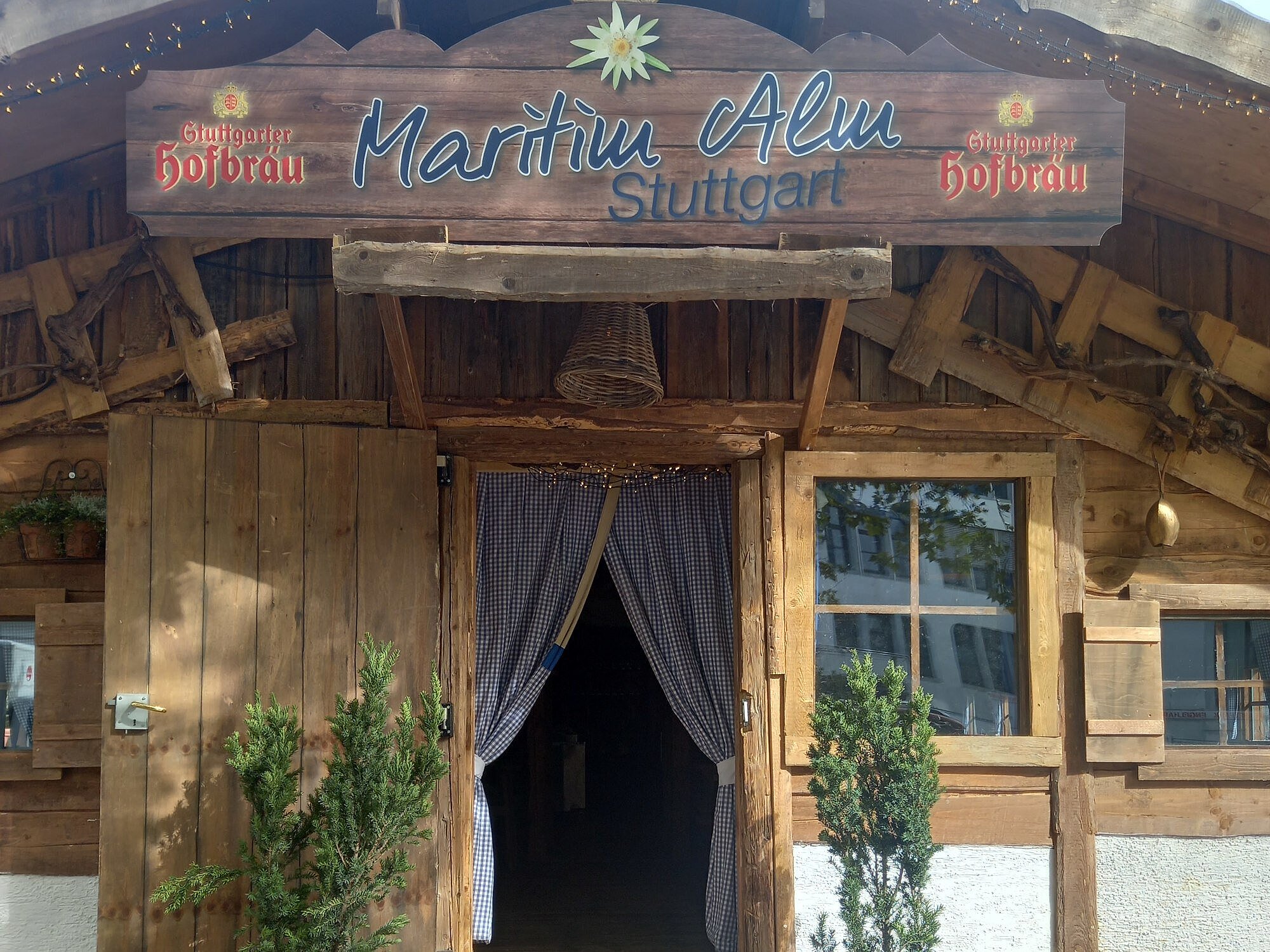 Entrance with wooden facade and curtains to Maritim Alm next to Maritim Hotel Stuttgart