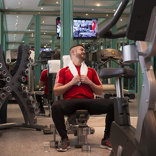 Huésped entrenando en el gimnasio del Maritim Hotel Stuttgart con pesas y máquinas