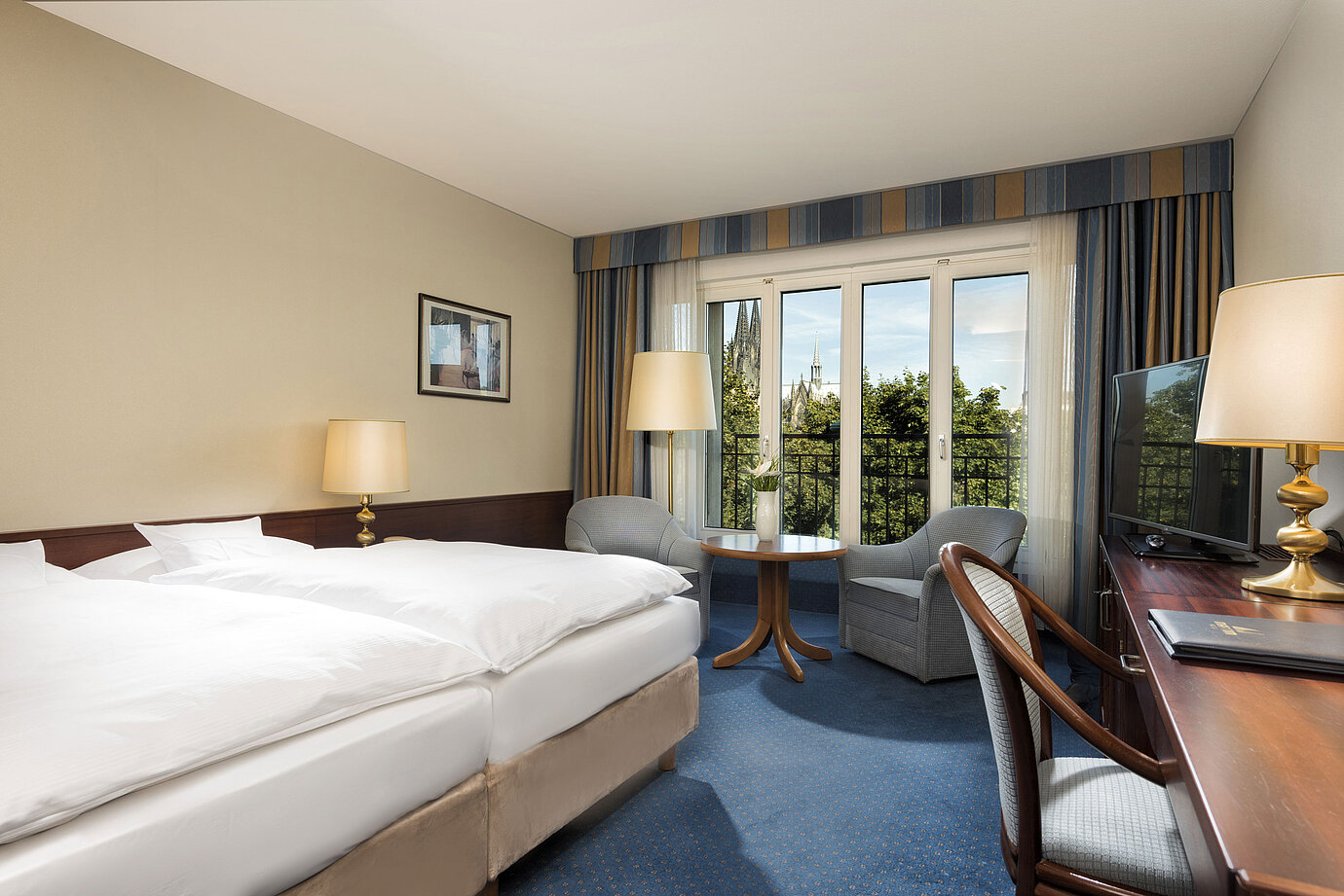 Superior double room at Maritim Hotel Cologne with cozy decor and view of the Cologne Cathedral.