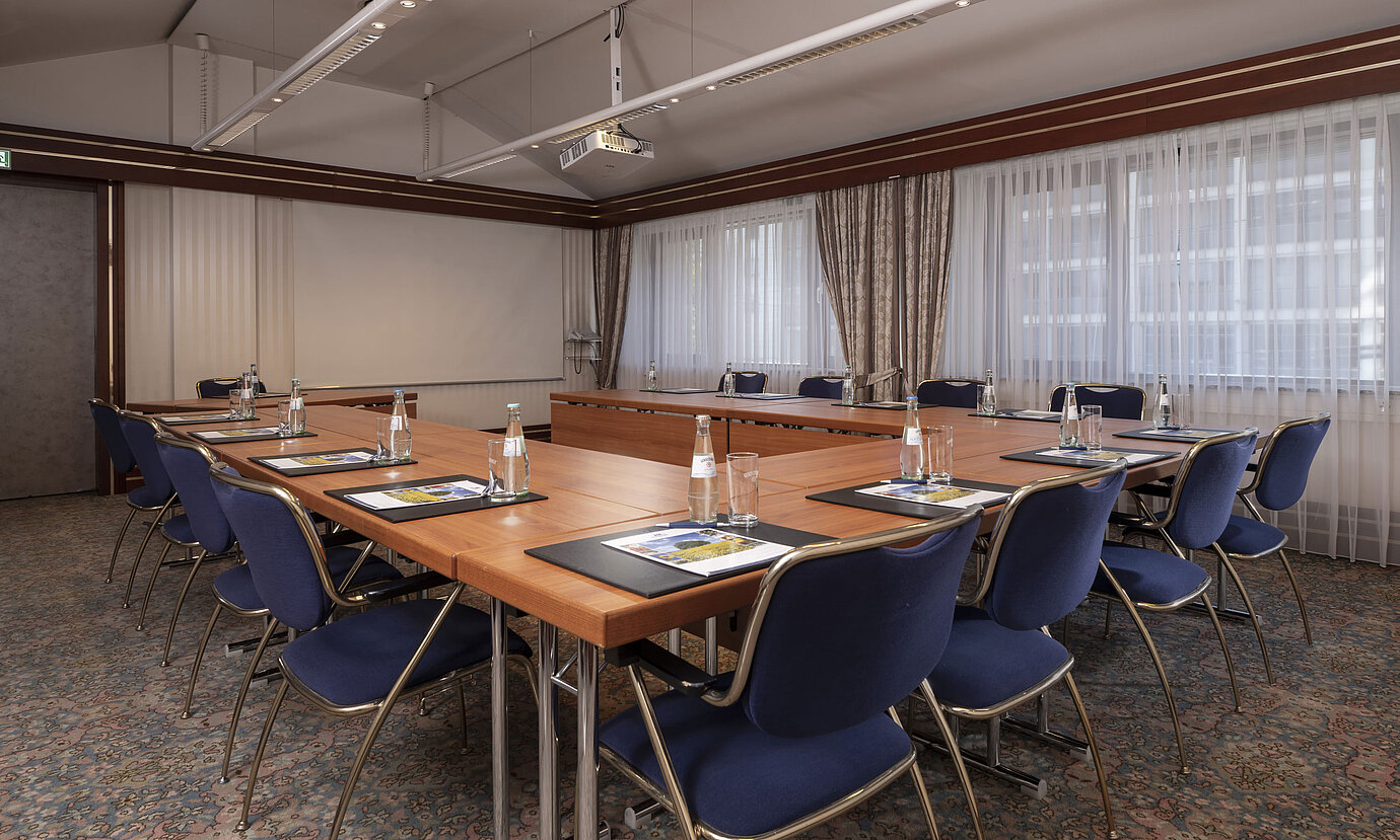 Salle de conférence moderne au Maritim Hotel Magdeburg avec disposition en U, lumière naturelle et équipements de qualité.