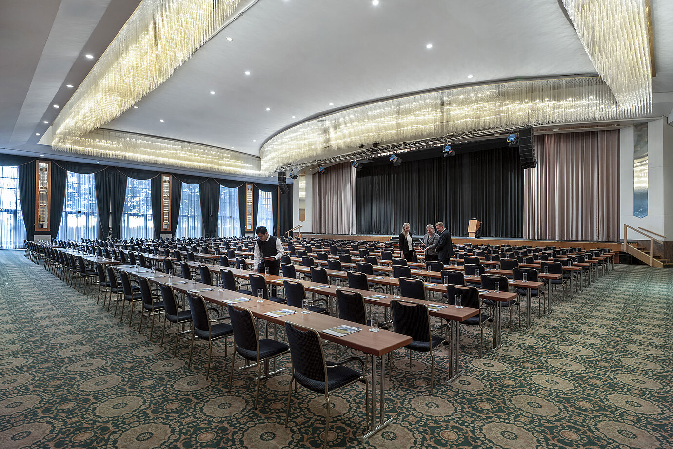 Salle magnifique au Maritim Hotel Magdeburg avec une scène, des sièges en rangée et un lustre luxueux.