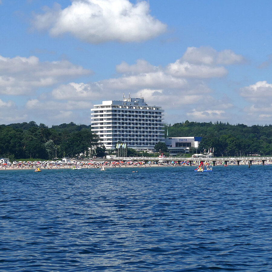 Maritim Seehotel Timmendorfer Strand, jetée et drapeaux colorés depuis un bateau par temps ensoleillé.