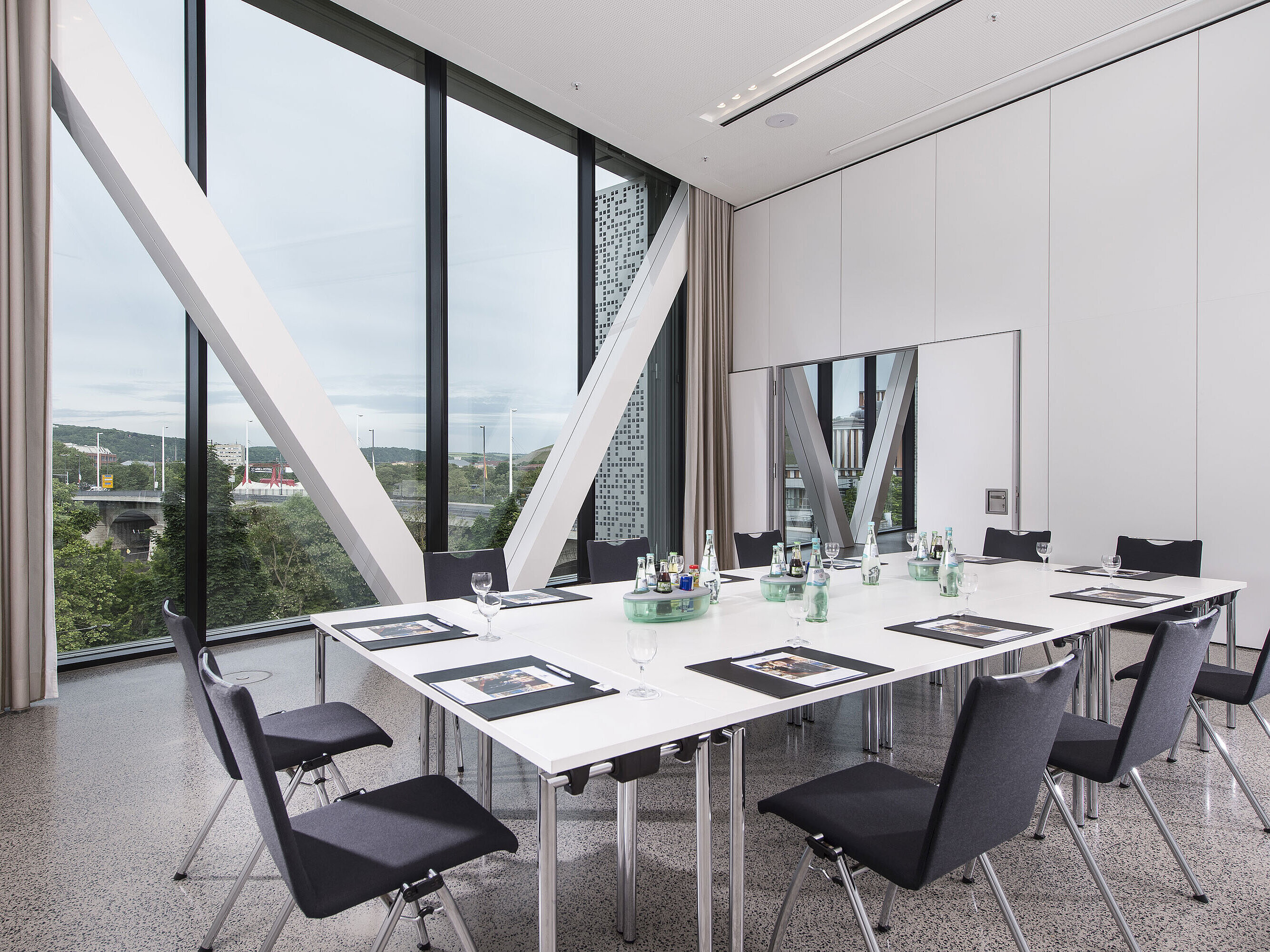 Sala de reuniones luminosa del Maritim Hotel Würzburg con gran ventana y vista al puente antiguo