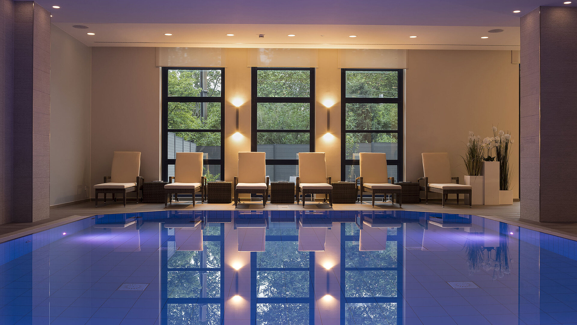 Piscina Área de piscina del Hotel Maritim Bonn con elegantes tumbonas e iluminación calmante para una relajación total.