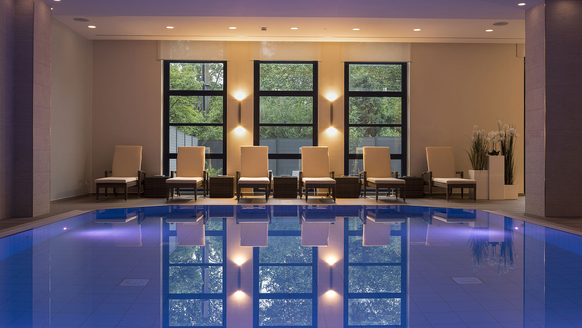 Pool area at Maritim Hotel Bonn with stylish loungers and calming lighting for ultimate relaxation.