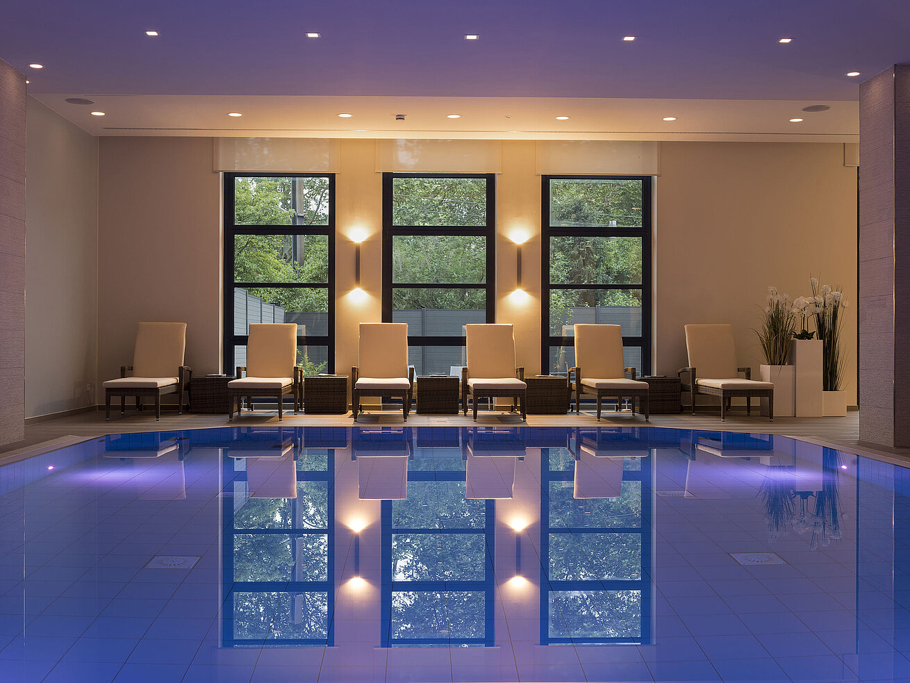 Piscina Área de piscina del Hotel Maritim Bonn con elegantes tumbonas e iluminación calmante para una relajación total.