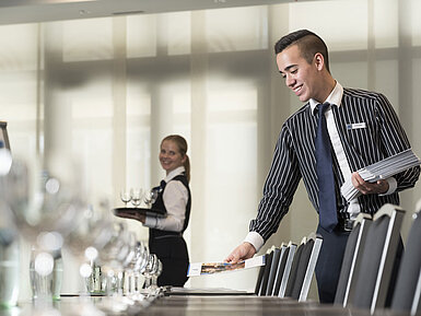 Équipe de service amicale à l'hôtel Maritim Bad Homburg préparant la salle de conférence.