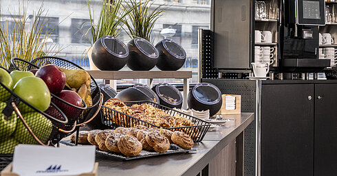 Diverse coffee and snack selection at the Maritim Hotel Magdeburg with fresh pastries, fruit, and modern coffee machines.