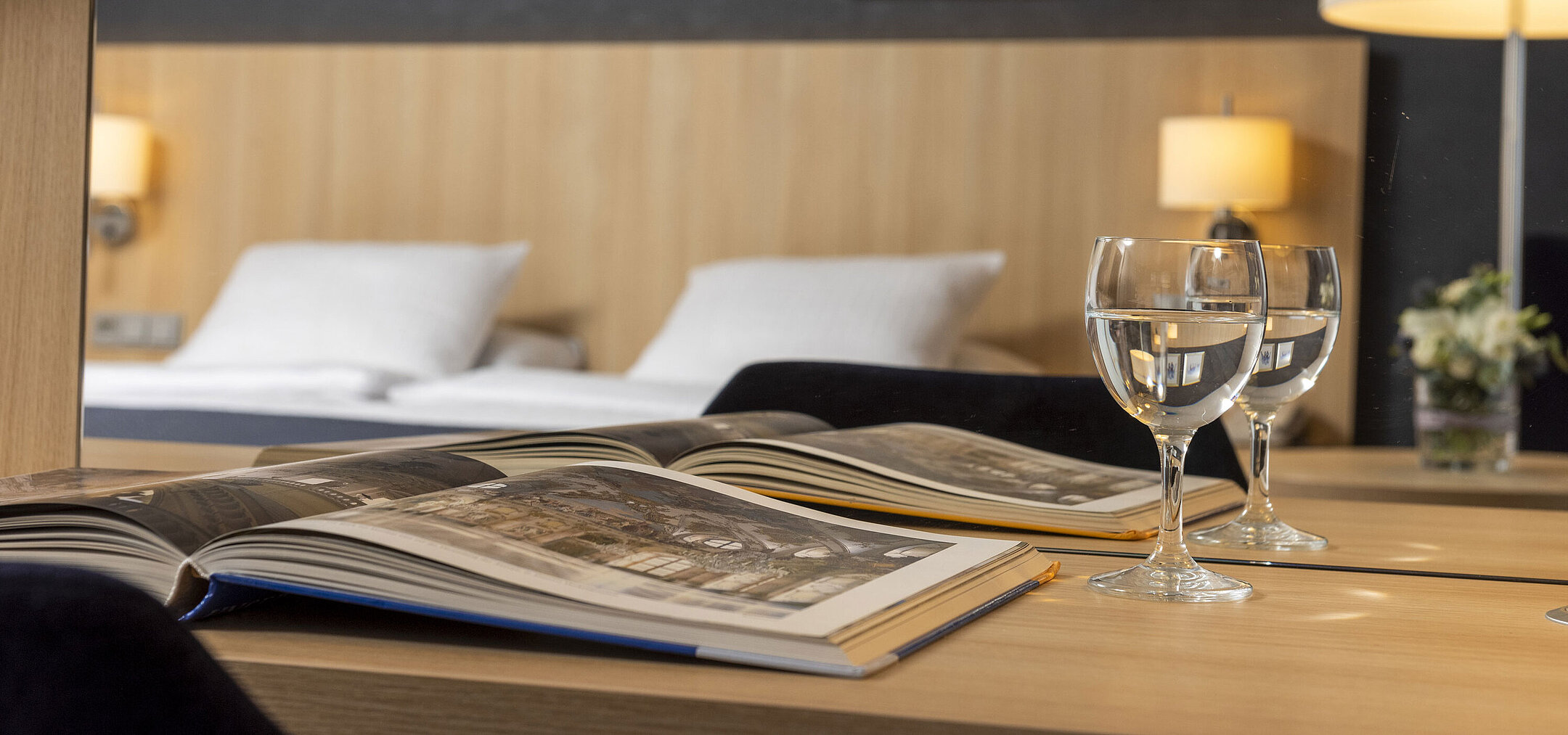 Acogedora habitación Comfort en el Maritim Hotel Würzburg con espejo, libro abierto y vasos de agua