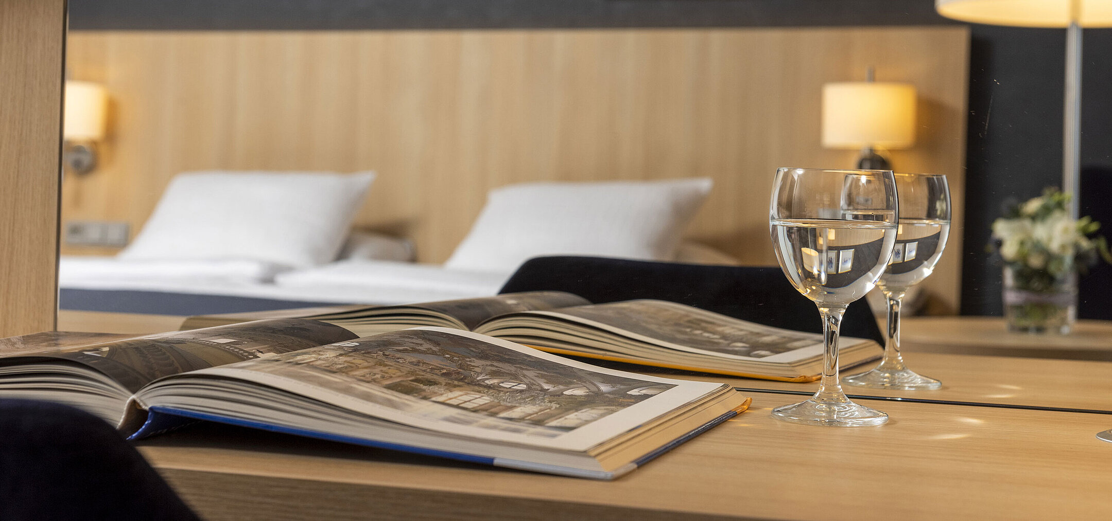 Acogedora habitación Comfort en el Maritim Hotel Würzburg con espejo, libro abierto y vasos de agua