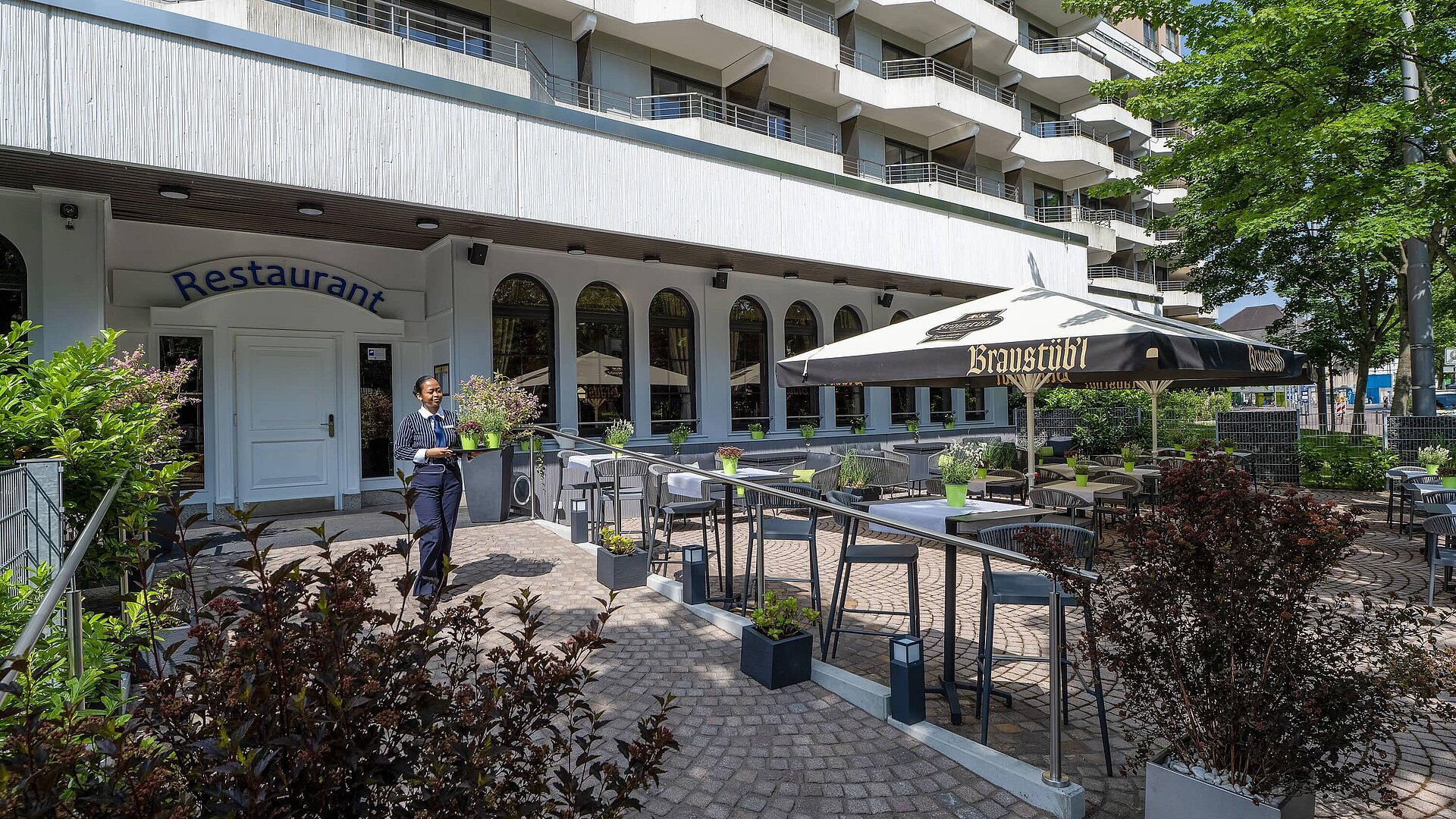 Restaurant terrace Summer restaurant terrace of the Maritim Hotel Darmstadt with exterior facade and tables under a parasol