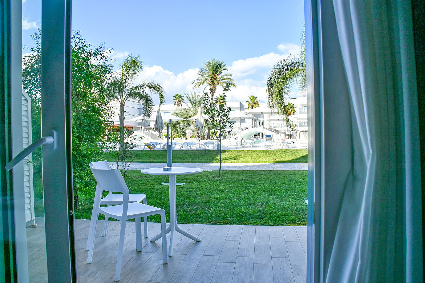 Terrazza privata al piano terra del Maritim Resort Calabria con vista su giardino e piscina