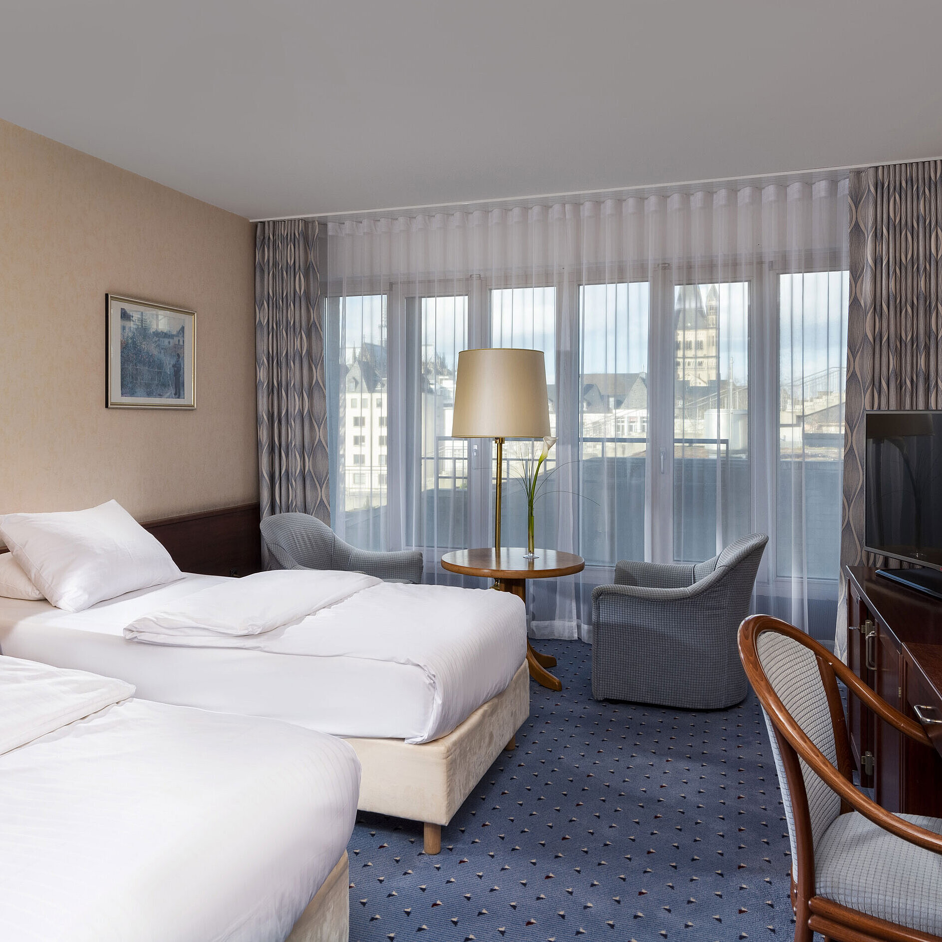 Standard Standard Twin Room at Maritim Hotel Cologne with two beds, seating area, desk, flat-screen TV, and large windows.
