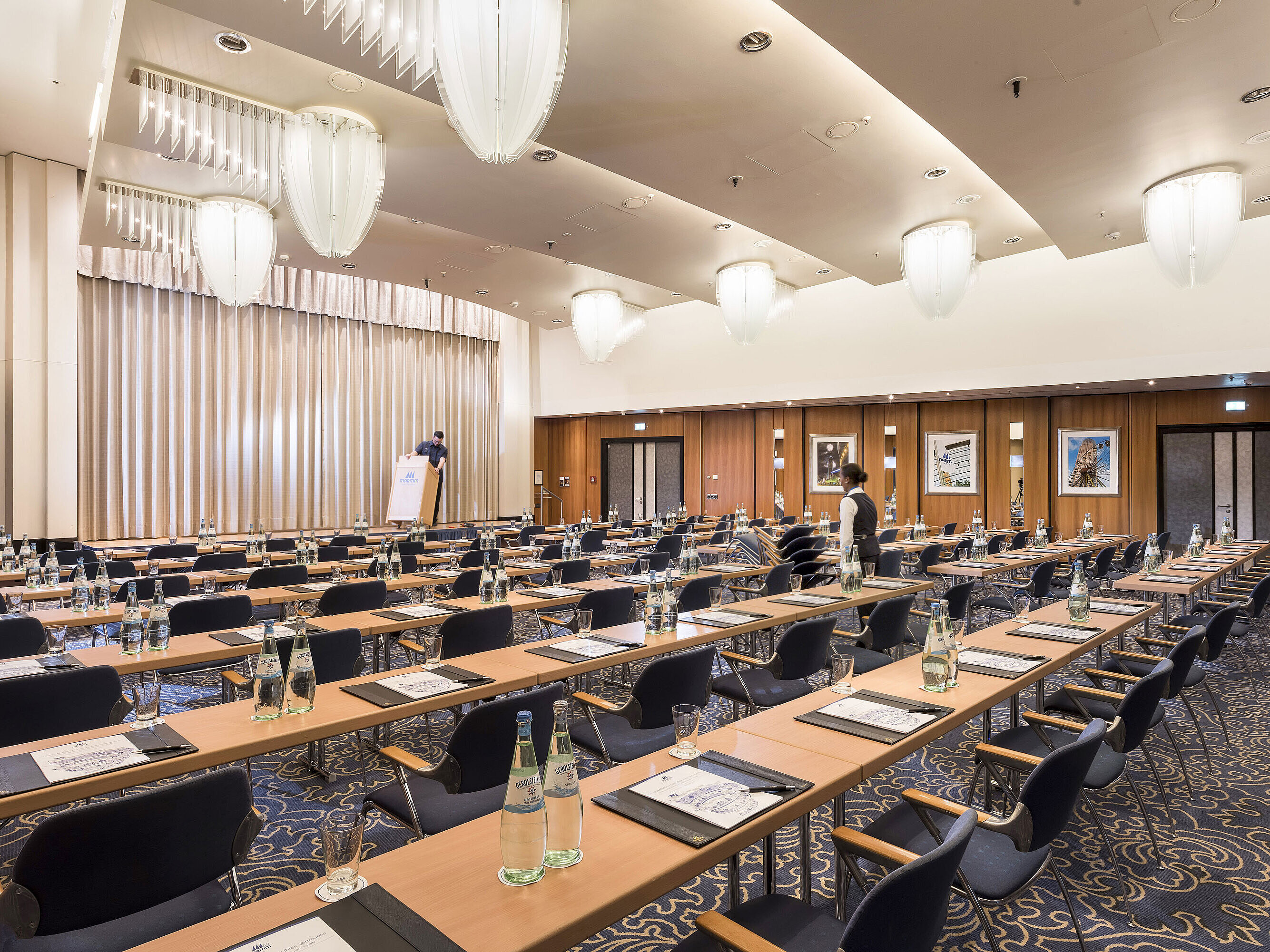 Gran sala de conferencias en el Maritim Hotel Frankfurt con sillas en fila, escenario y equipamiento moderno.