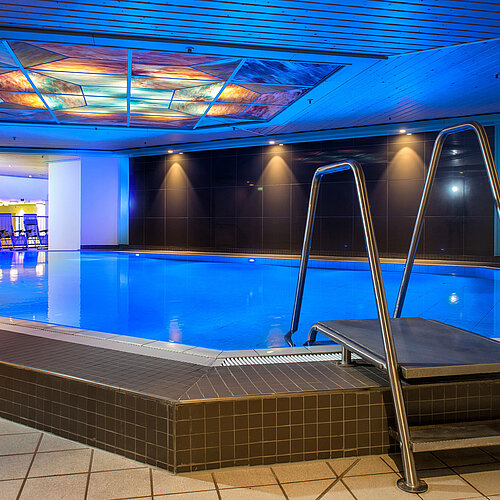 La piscine intérieure éclairée de l'hôtel Maritim, invitant à la détente et à la récréation.