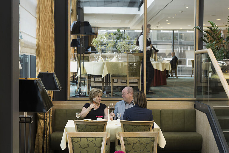 Guests enjoying a glass of wine in a cozy atmosphere at the restaurant of Maritim Hotel Dresden.