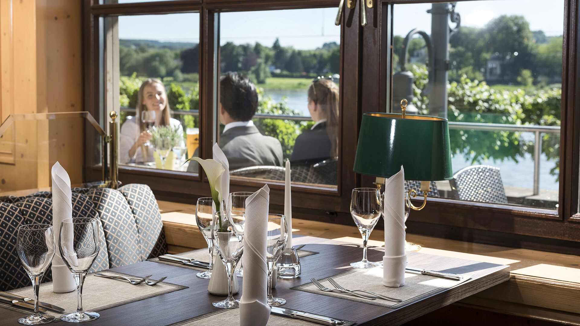 Stylishly set table in the restaurant of Maritim Hotel Königswinter overlooking the Rhine and nature.