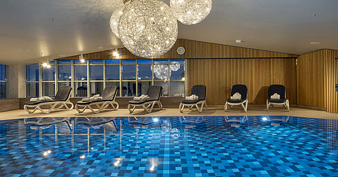Blue-tiled pool and lounge chairs at the Maritim Hotel Munich