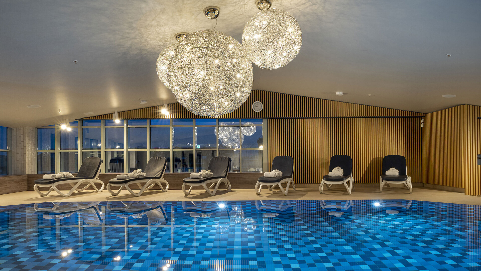 Piscine carrelée bleue avec transats à l’hôtel Maritim Munich