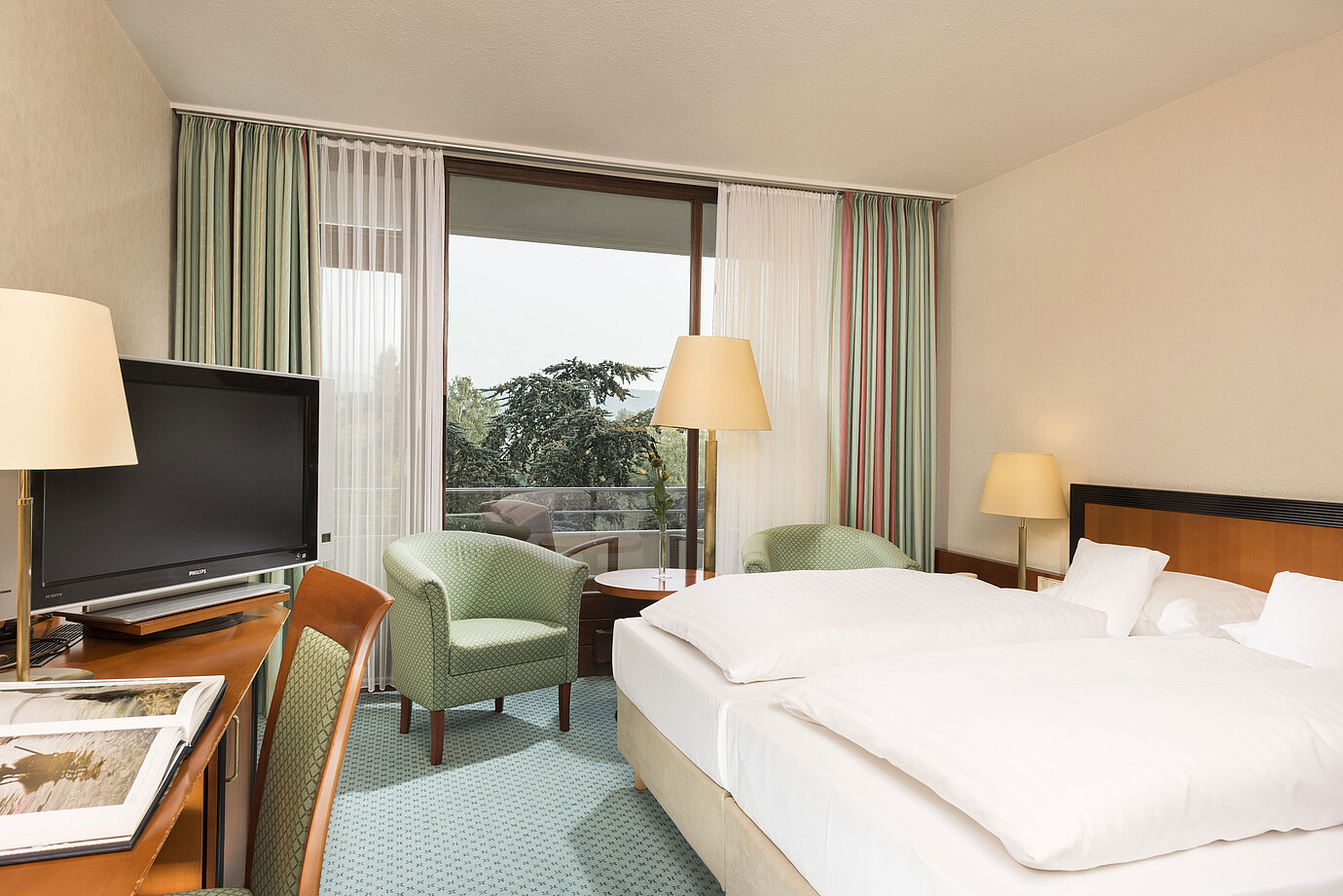 Camera luminosa al Maritim Hotel Bad Salzuflen con letto doppio, salottino e accesso al balcone