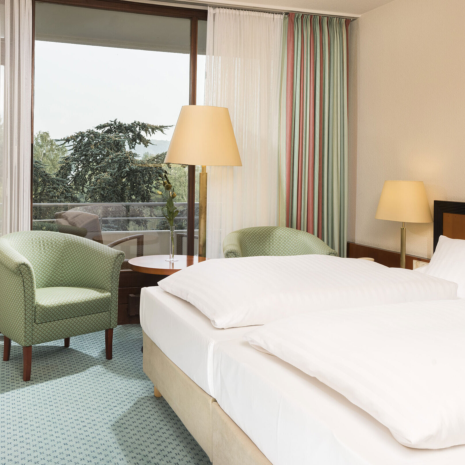 Camera luminosa al Maritim Hotel Bad Salzuflen con letto doppio, salottino e accesso al balcone