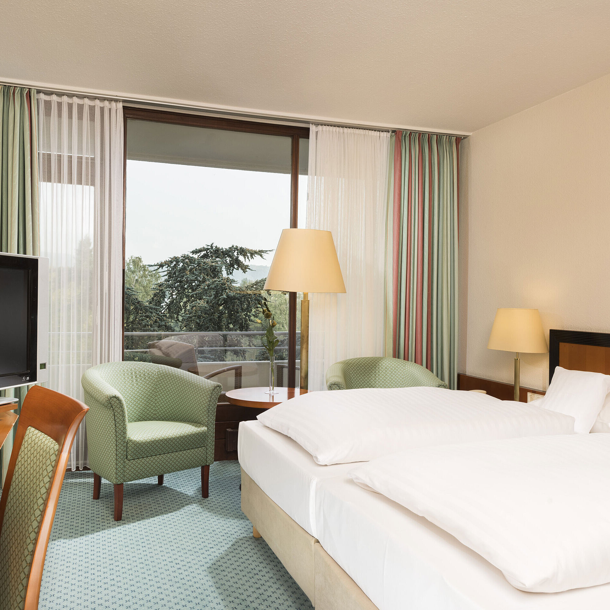 Camera luminosa al Maritim Hotel Bad Salzuflen con letto doppio, salottino e accesso al balcone