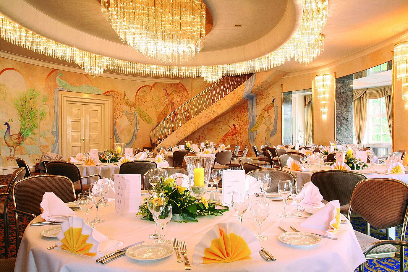 Salle de banquet élégante avec fresques murales, lustres et tables dressées