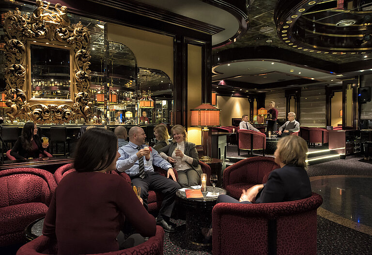 Huéspedes relajándose en el elegante bar del Hotel Maritim Bonn, disfrutando de bebidas en un ambiente agradable.