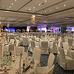 Festively decorated tables with candles and decor for a New Year's Eve party in the large banquet hall of Maritim Berlin.