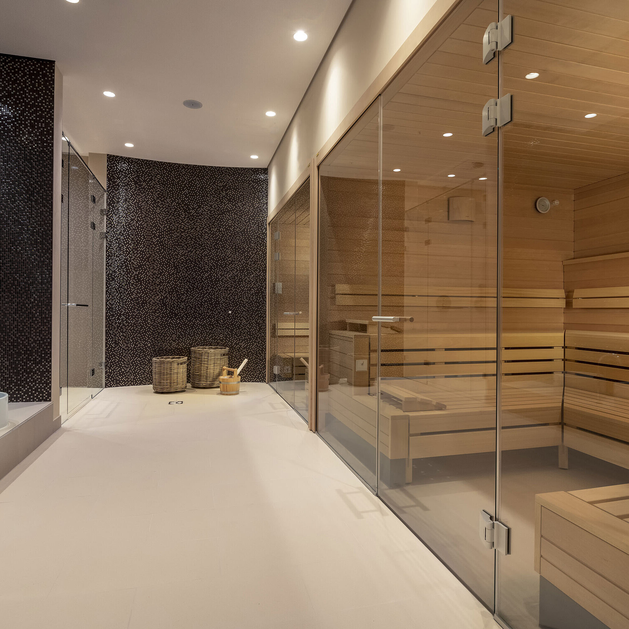 Modern spa area with glass sauna, cozy seating, and a stylish atmosphere at Maritim Hotel Ingolstadt.