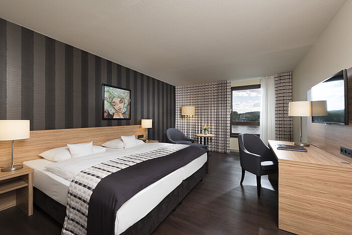Habitación doble elegante del Maritim Hotel Königswinter con vistas al Rin y diseño moderno.