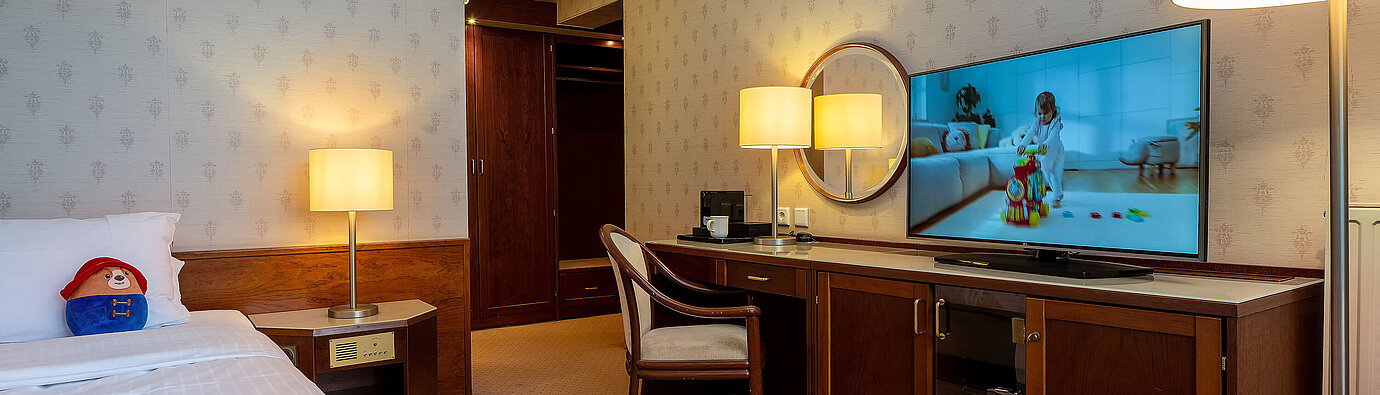 Camera familiare Superior con letto, grande TV, scrivania e accogliente zona soggiorno.