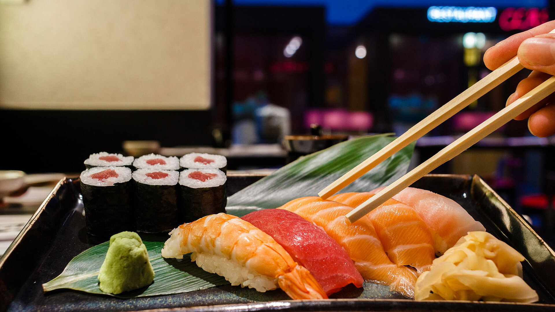 Fresh sushi at Maritim Hotel Düsseldorf with salmon, tuna, shrimp, maki, wasabi, and ginger, served on a stylish plate.