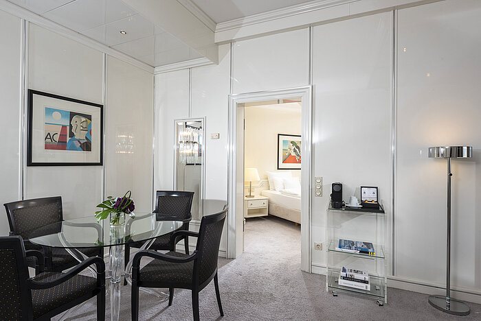 Suite Exécutive lumineuse au Maritim Hotel Frankfurt avec coin repas élégant, table en verre et accès direct à la chambre.