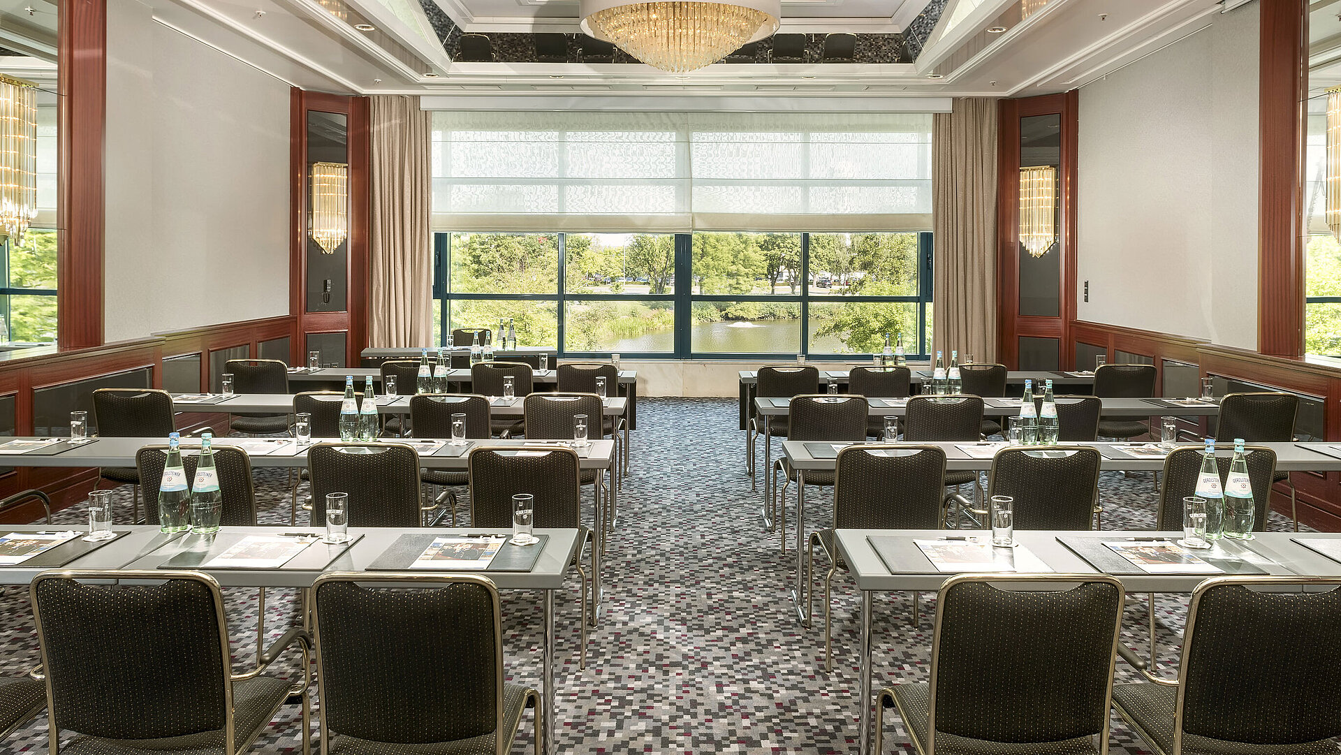 Sala de conferencias moderna en el Maritim Hotel Hannover con diseño elegante, luz natural y vista verde.