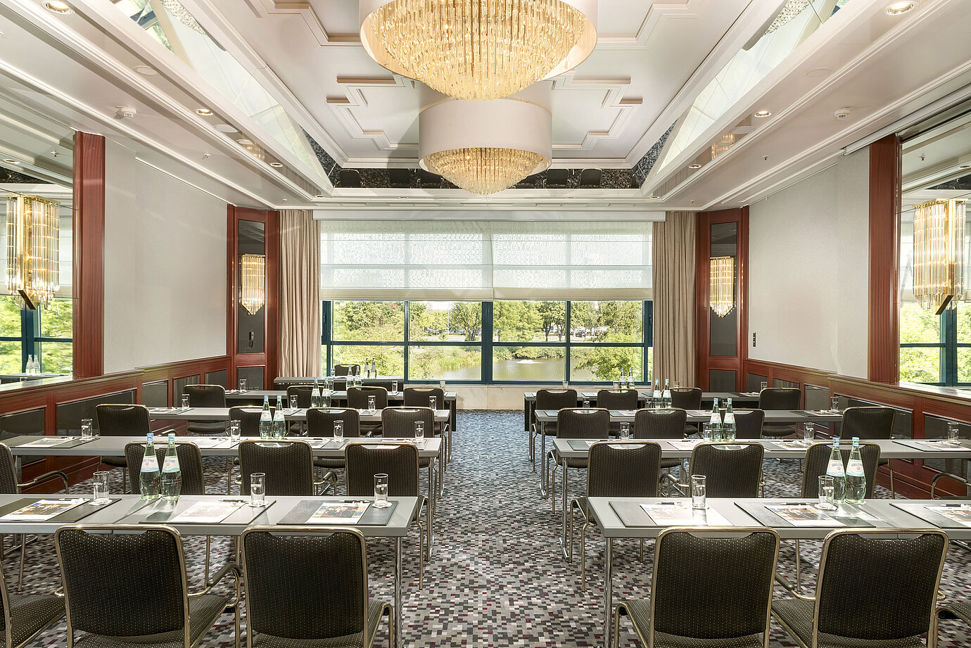Sala de conferencias moderna en el Maritim Hotel Hannover con diseño elegante, luz natural y vista verde.