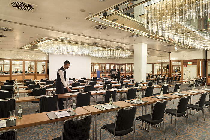 Sala con asientos en fila y lámparas en Maritim Hotel Múnich