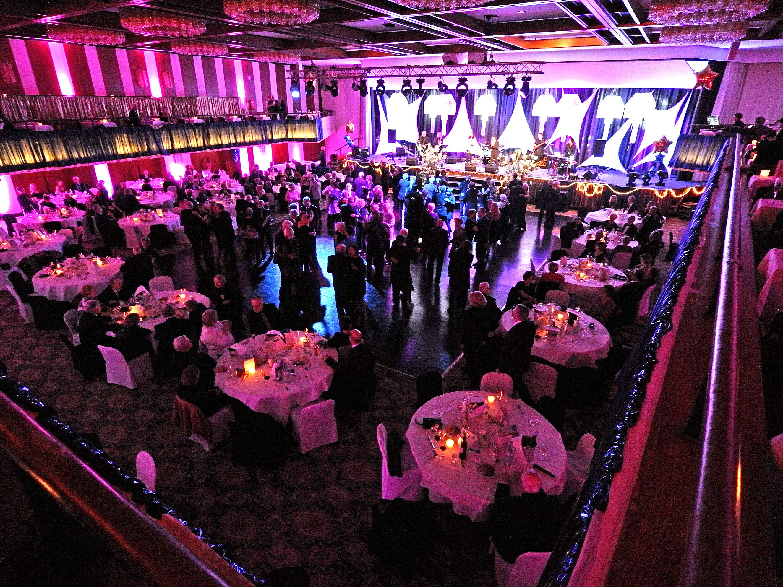 Evening event with stage and banquet seating in festively lit hall of Maritim Hotel Travemünde